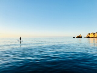Naklejka premium Sunrise paddle board along the Algarve coast of Portugal