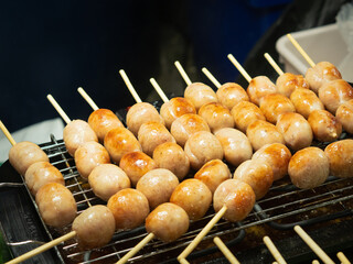 Thai Sausage (Isaan Sausage) is made from sticky rice, pork, and seasonings. Grilled skewers on the stove. - 558563201