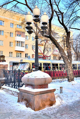 Street lamp in the city square on a winter morning