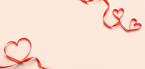 Hearts made of red ribbons on beige background with space for text. Valentine's Day celebration