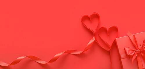 Hearts made of ribbon and gift on red background with space for text. Valentine's Day celebration