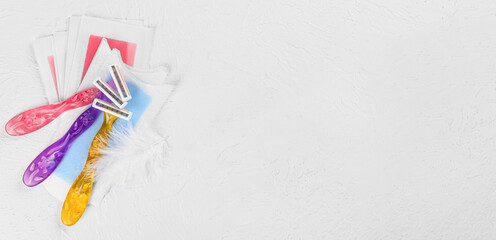 Set of shaving razors and wax strips on white textured background with space for text