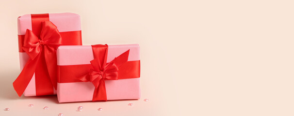 Beautiful gift boxes for Valentine's Day celebration on beige background with space for text