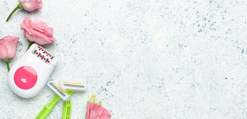 Modern epilator, flowers and shaving razors on light background with space for text