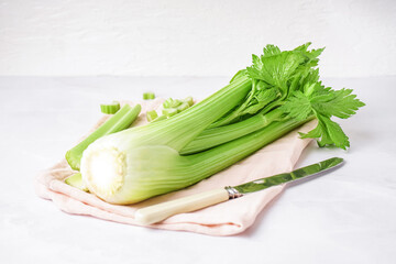 Napkin with fresh celery on light background