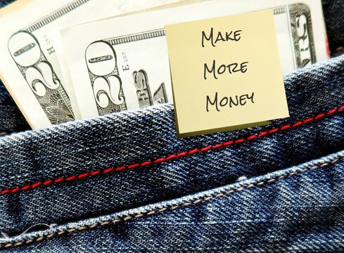 Cash money dollar in jeans pocket with note written MAKE MORE MONEY , concept of money making side hustle - young business owner set goal to earm nore income