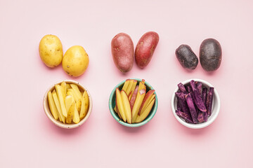 Bowls with cut and whole raw potatoes on pink background