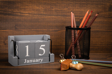 15 January inscription on wooden calendar. Wooden office desk