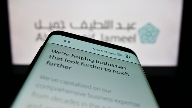 Stuttgart, Germany - 12-25-2022: Smartphone with website of Saudi Arabian company Abdul Latif Jameel (ALJ) on screen in front of business logo. Focus on top-left of phone display.