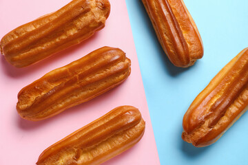 Delicious eclairs on color background