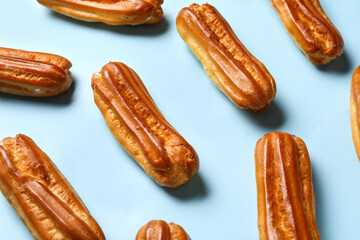 Many sweet eclairs on color background
