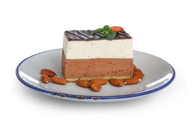 Plate with piece of birds milk cake, almond nuts and mint leaves isolated on white background