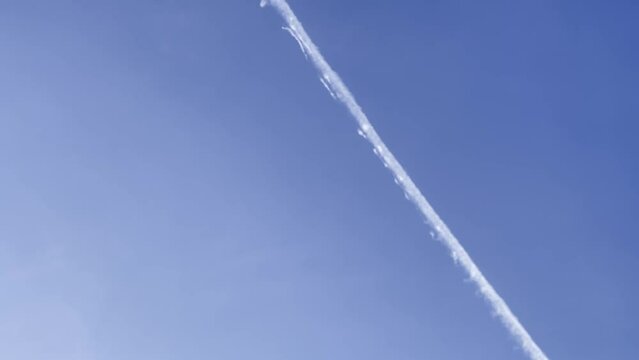 Condensation trails chemtrails line in a blue sky airplane trail, 4k cinematic shot