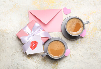 Cups of latte with gift, envelope and lipstick kiss on grunge background. Valentine's Day celebration