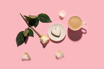 Cup of latte with cookie and rose on pink background. Valentine's Day celebration