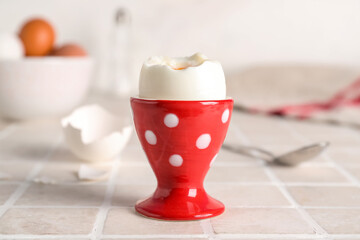 Cup with soft boiled egg on table