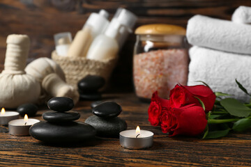 Fototapeta na wymiar Beautiful spa composition for Valentine's Day with stones, candles and rose flowers on wooden background
