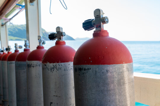 A row of compressed air tanks like those used on scuba diving trips.