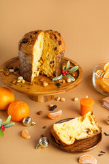 Stand with cut Panettone and Christmas decor on beige background