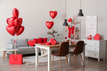 Interior of dining room decorated for Valentine's Day with table, sofa and balloons