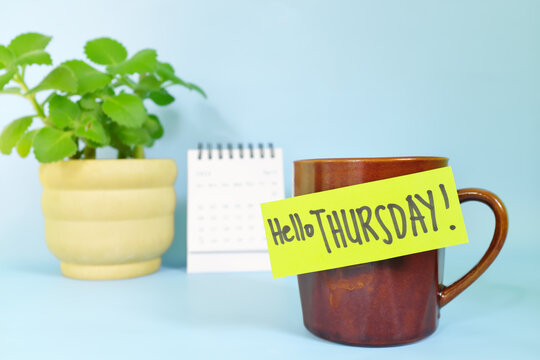 Welcome, hello and happy Thursday concept. Selective focus of coffee cup with green paper note and written message.