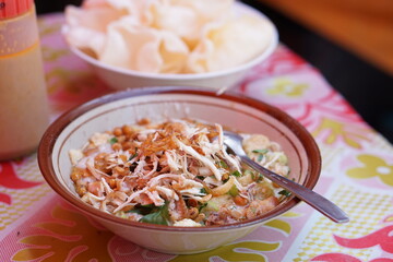 nesian rice porridge served with shredded chicken.