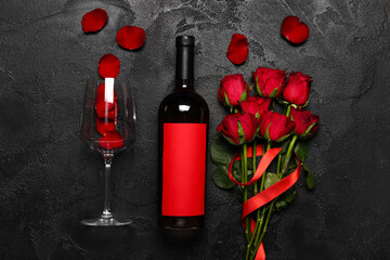 Red roses, bottle of wine and glass on dark background. Valentine's Day celebration