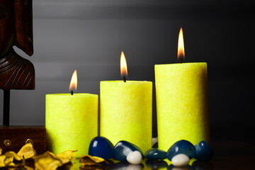 Yellow candles burning on dark background