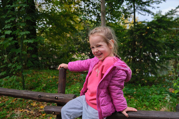 Little girl funny happy face expression walk outdoor green park