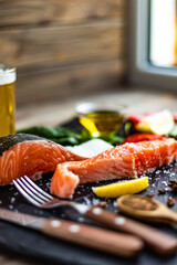 Side view of two pieces of raw salmon fillet preparing for cooking on stone cutting board. Good food
