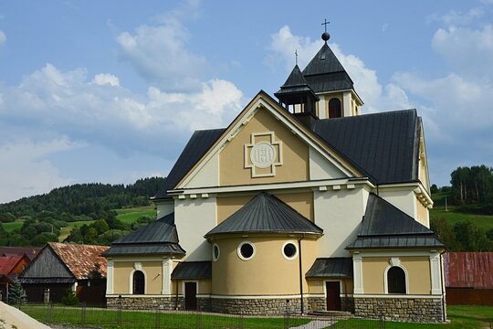 New catholic rectory and church of Assumption of Virgin Mary in pseudo romanesque style in Zazriva, Terchova region, northern Slovakia, during partially cloudy summer day. 