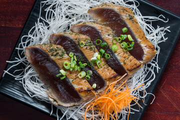 Japanese style of temaki with fillet of mackerel fish served julienned vegetables and leek on black...