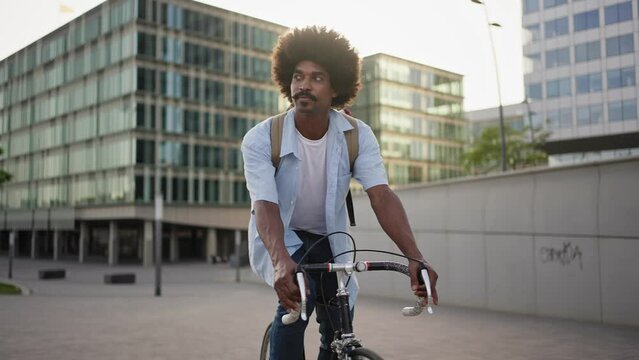 Young African American man riding bike in the city 
