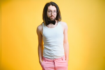 Obraz premium Gay man on a colored background in the studio. The concept of the LGBTQ community. Equality.