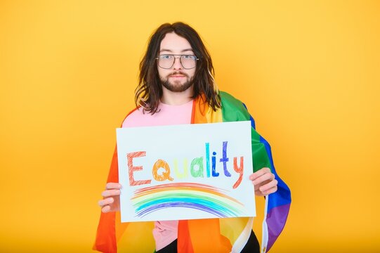 Hands of gay man holding lgbt banner on rainbow flag background lgbt symbol