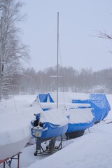 Yacht, boat, ship on the shore under a canopy awning in the snow