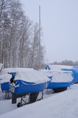 Yacht, boat, ship on the shore under a canopy awning in the snow