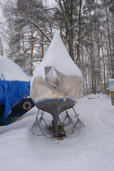 Yacht, boat, ship on the shore under a canopy awning in the snow