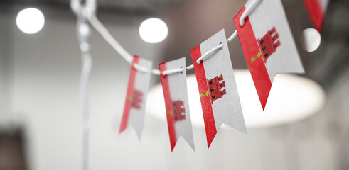 A garland of Gibraltar national flags on an abstract blurred background