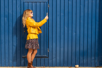 full length middle-aged woman walking looking at mobile phone