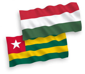National vector fabric wave flags of Togolese Republic and Hungary isolated on white background. 1 to 2 proportion.