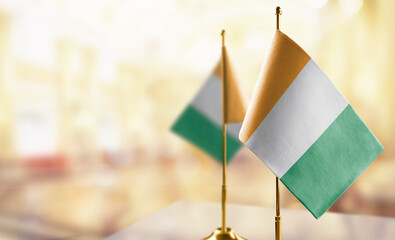 Small flags of the Cote dIvoire on an abstract blurry background