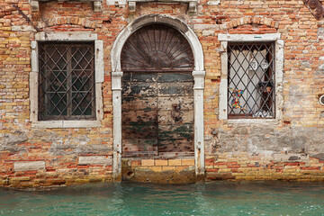 Fragment of the facade of an old tenement house in Venice, Italy