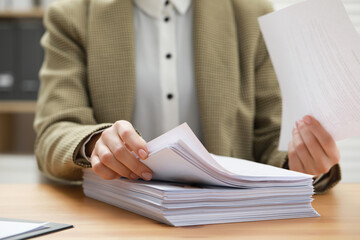 Woman working with documents at table in office, closeup