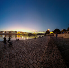 Obraz premium bonito atardecer junto al puente de Triana en la ciudad de Sevilla, España
