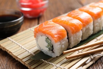 Tasty sushi rolls served on wooden table, closeup