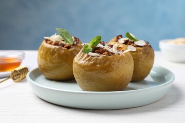 Baked apples on white wooden table, closeup