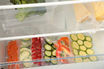Vacuum bags with different vegetables in fridge. Food storage