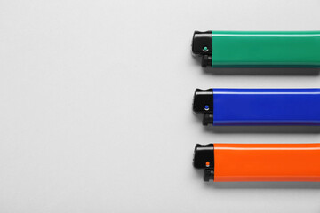 Stylish small pocket lighters on white background, flat lay. Space for text