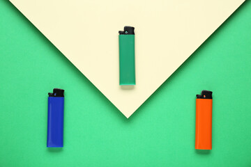 Stylish small pocket lighters on color background, flat lay
